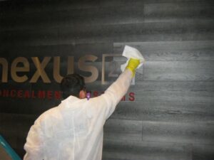 Worker cleaning an industrial surface under controlled conditions