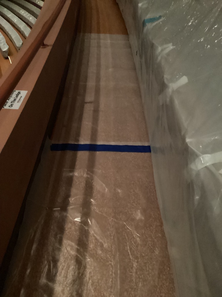 Floor protection secured with blue tape in an auditorium aisle